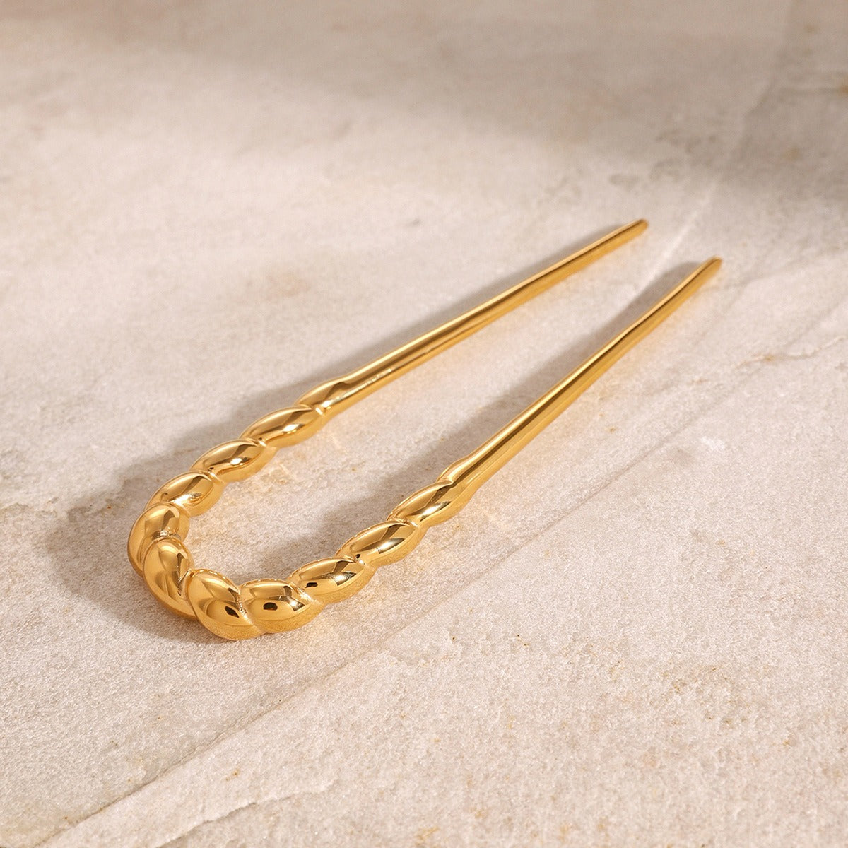  Close-up of twisted metal texture on 18K gold hair accessory — MINIMAL